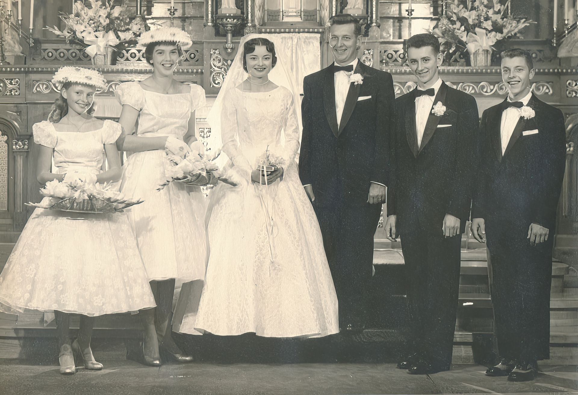 A traditional 1950s Las Vegas wedding photo with the bride, groom, best men, and bridesmaids in black and white.